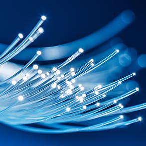 Bundle of optical fibers with lights in the ends. Blue background 293x293